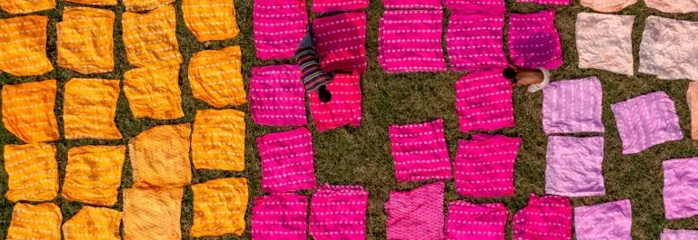 Colourful fabrics and workers &copy; Adobe Stock