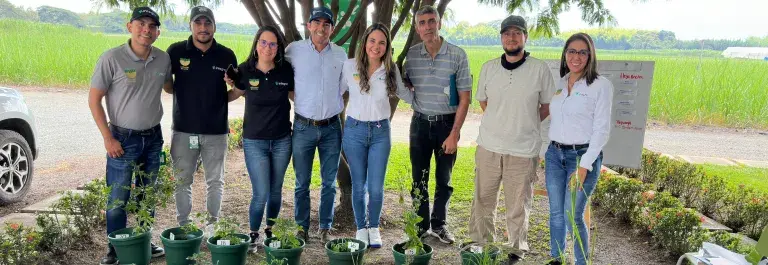 Group of adults standing in front of plant pots