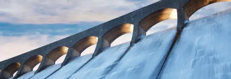 Hydropower dam with water running down a concrete slope © Adobe Stock