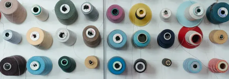 Rows of different coloured threads for embroidery © Pexels