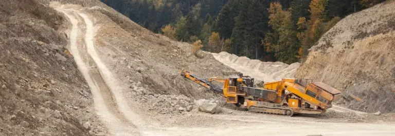 Bulldozer driving across a mine in the hills © Pexels