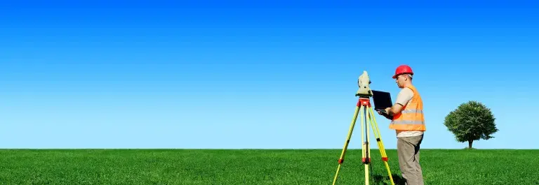 Man collecting data in a green field with bright blue sky © Adobe Stock