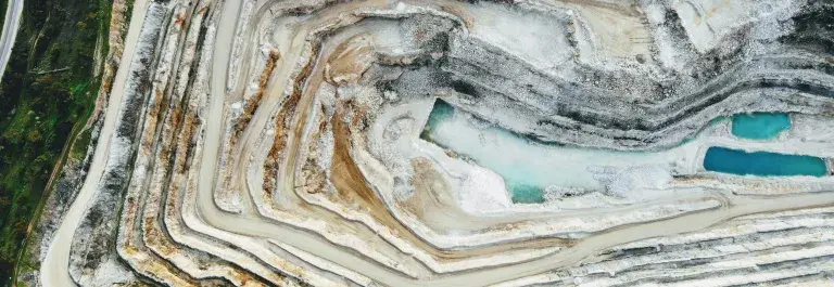 Aerial view of a white mine with layers and hills © Unsplash