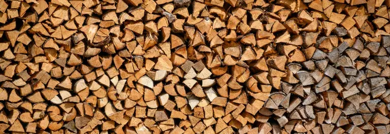 Hundreds of pieces of chopped wood stacked close together © Unsplash