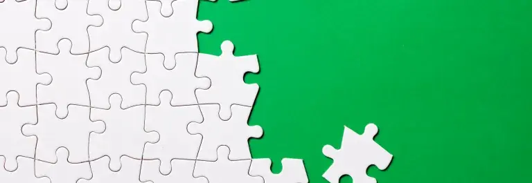 White puzzle pieces fitting together against a bright green background