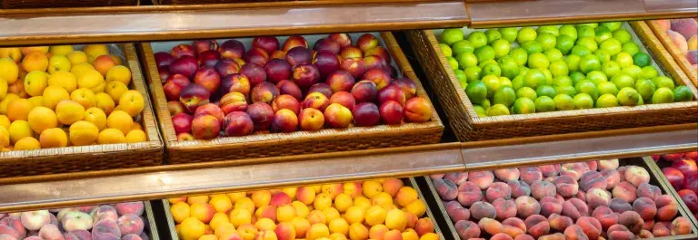 Assortment of fresh fruits on store shelves, on market counter