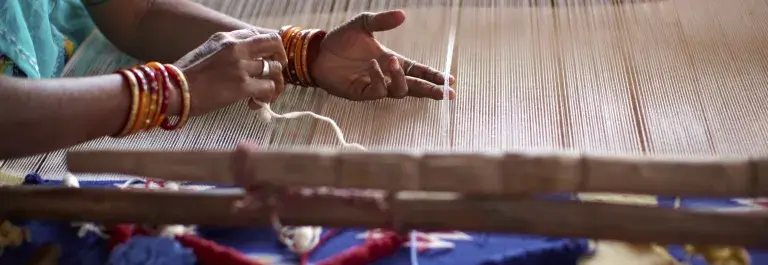 Woman weaving by hand on a loom