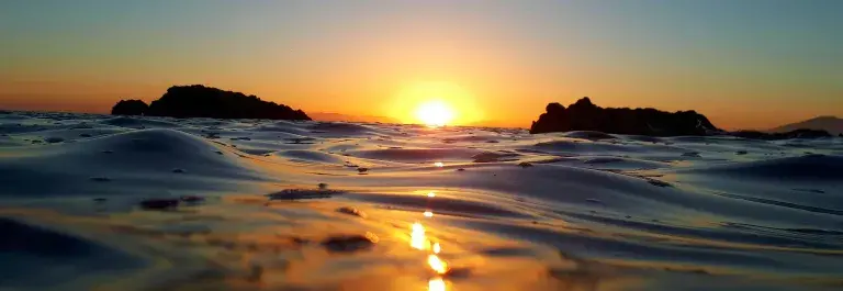 Sunset on the horizon creating gorgeous blue and orange reflections on the ocean © Unsplash