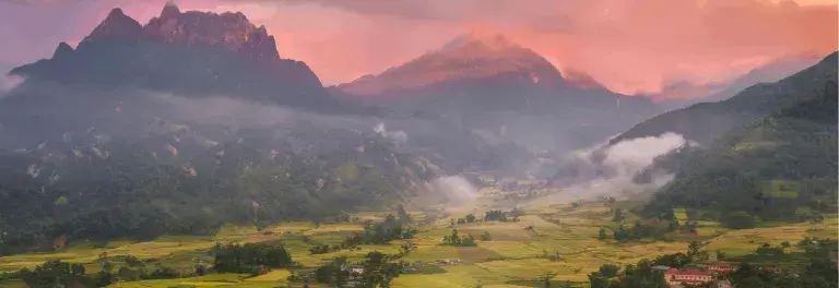 Landscape with a sunset across the mountains. ahead, you can see agricultural fields