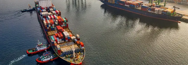 Shipping containers on a container ship near a dock © Pexels