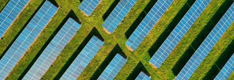 Aerial view of solar panels in green space