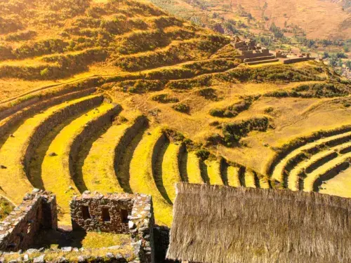 Landscape of farming on a large yellow hill with small buildings