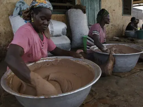 Women of the Tung-Teiya Shea Butter Extraction Women's Association (TUSEWA) make shea butter by hand from roasted shea nuts in Tamale, Ghana, June 23, 2006. Photo: Jonathan Ernst / World Bank. Photo ID: JE-GH060624_33967 World Bank