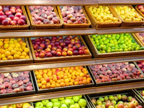 Assortment of fresh fruits on store shelves, on market counter