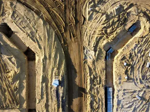 Aerial view of vans around a sandy mine © Unsplash