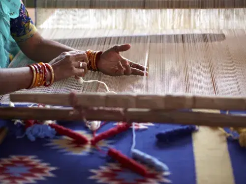 Woman weaving by hand on a loom