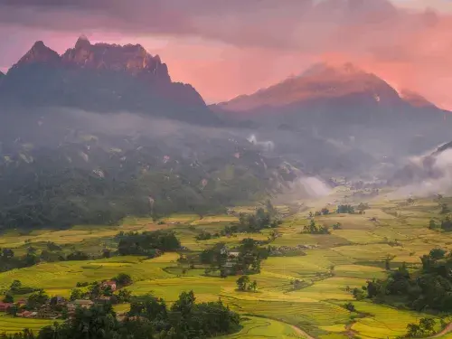 Landscape with a sunset across the mountains. ahead, you can see agricultural fields