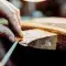 Person filing metal down by hand to create jewellery on a working bench