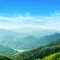 Green landscape of mountains covered in forest with a river © Adobe Stock