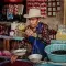 A man weighs beans at his market stall