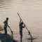 Two people fishing by the side of a river with nets © Unsplash