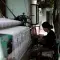 Woman textile worker sitting by weaving equipment with white yarn © Unsplash