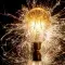 Light bulb against a dark background with light beams scattered around